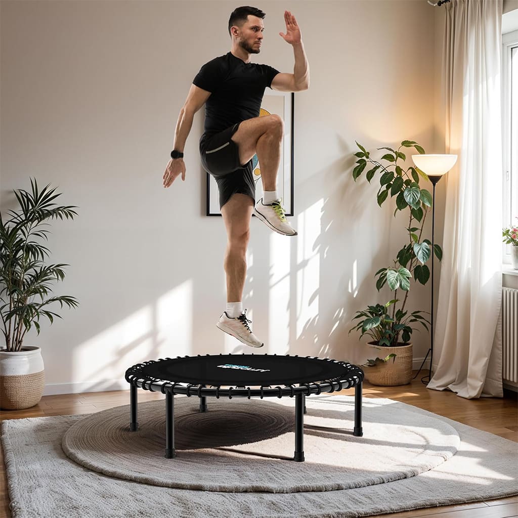 Uomo salta sul trampolino Pura Neve AirBounce in un ambiente domestico, migliorando equilibrio e vitalità.